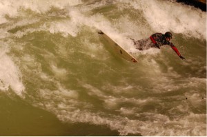 Eisbach-Surfer in München auf einer sogenannten stehenden Welle am Haus der Kunst